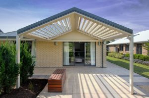 Modern patio with louvered roof and bench seating.